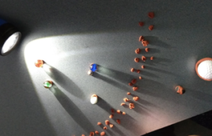 Several marbles, representing planets, with a light shining from the top representing the sun.